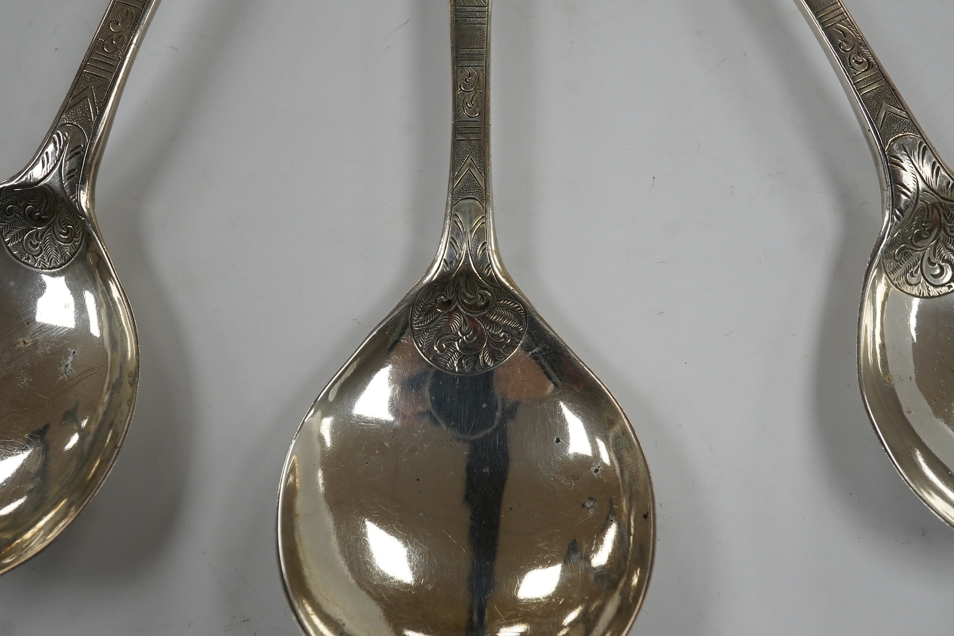 Five assorted George III and later serving spoons with later engraved decoration, earliest London, 1791, 16.8cm, 6.4oz. Condition - fair
